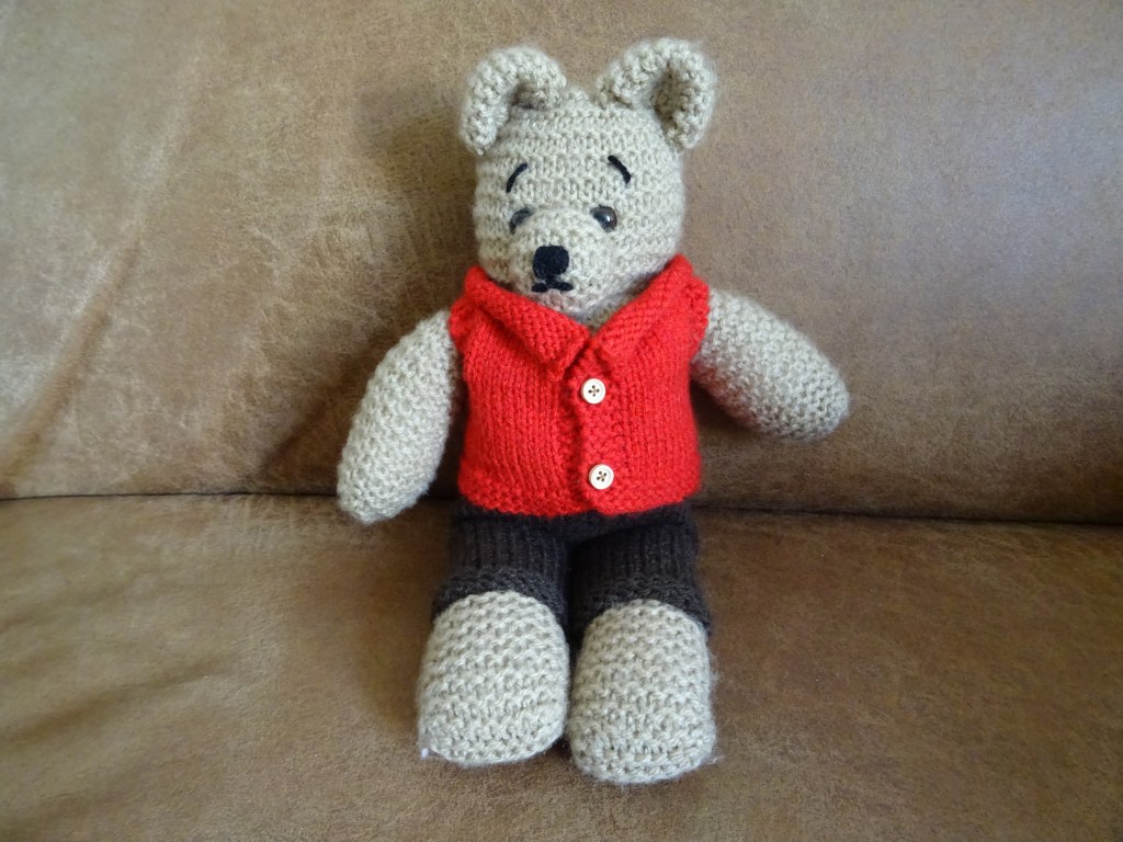Gebreide knuffelbeer met een broek en jasje aan