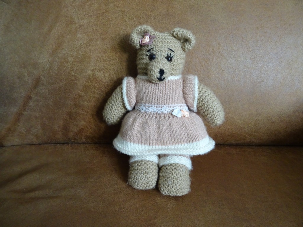 gebreid knuffelbeertje met een jurkje aan en daaronder een gestreepte legging